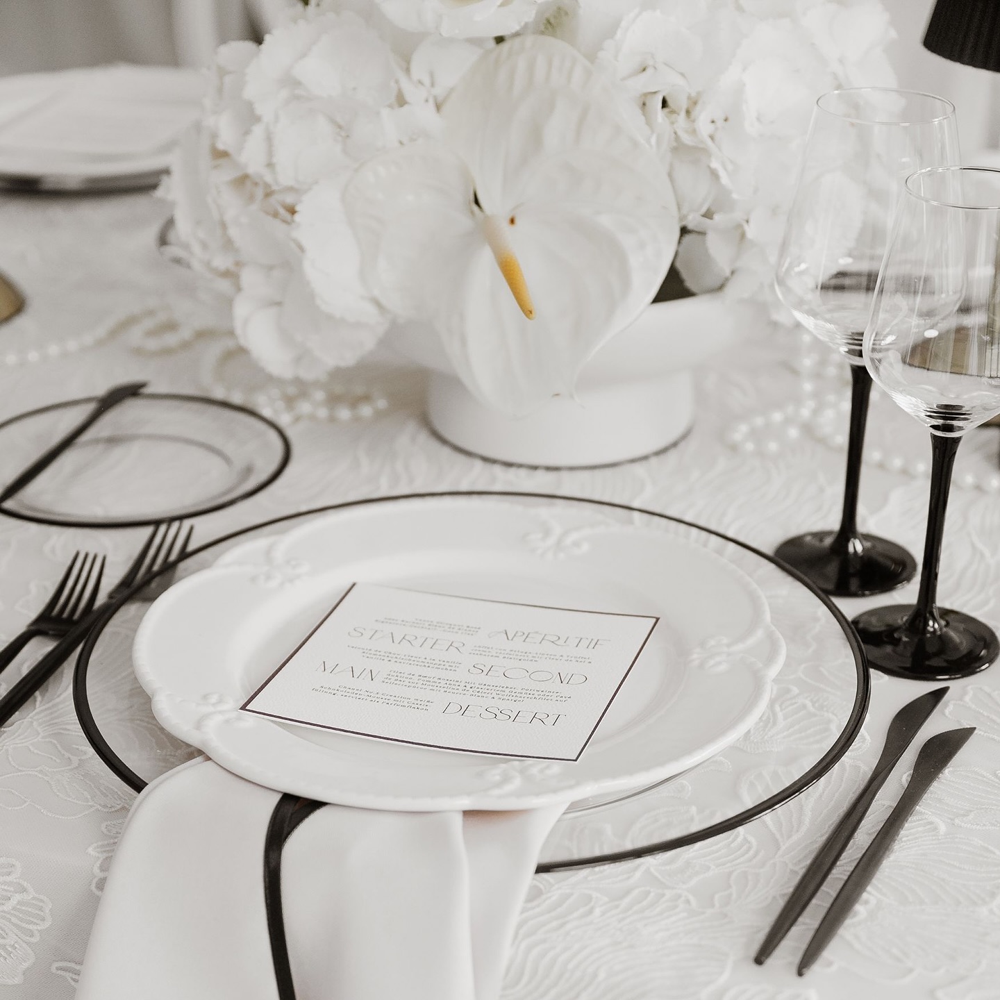 Black & White, but never boring. ⚫️⚪️⁠
⁠
Dieses Tischdesign setzt auf klare Kontraste, reduzierte Eleganz und feinste Details: schwarze Gläser, minimalistisches Besteck, Statement-Blüten und ein Hauch von Couture auf Porzellan.⁠
Ein Setting für alle, die Ästhetik bis ins letzte Detail denken.⁠
⁠
#tablesetting #weddingtable #modernwedding #blackandwhitewedding #weddinginspo #weddingdecor #elegantehochzeit #luxurywedding #bridetobe #weddingconcept #weddingdesign #weddingpapterie #papeterie #weddingstyle #weddingdetails #tablesettinggoals⁠
⁠
_____⁠
Fotografin: @oliviadelgas_photo⁠
Planung: @kh.hochzeiten⁠
Geschirr, Stühle & Dekoration: @hochzeitsdekorstion⁠
Floristik: @daniewilke_floraldesign⁠
Brautkleider: @diebrautmacherin⁠
Make-up: @nessbeautystudio & @mayestic.makeup ⁠
Hair: @haaratelier.cloppenburg⁠
Location: @lokschuppen.atelier.clp⁠
Catering: @ostblocklatino_soul⁠
Live Painting: @farbmomentebynica⁠
Patisserie: @konditorei_carlotta⁠
Papeterie: @creativitydesign___a⁠
Couple: @nina_deer_ @pa.tat_ @nrw.modelcouple⁠
Single Bride: @_kiikii_j⁠
Bridemaids: @lucia.stecklein @angeeloe @waleeriiaa⁠
Ohrringe&Tasche: @dilaaccessoires⁠
Herrenausstatter: @kramer_hannover