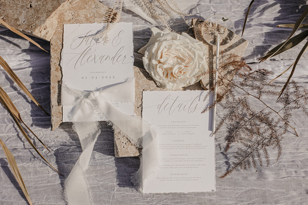 Hochzeitspapeterie auf Büttenpapier mit gerissenen Kanten und Chiffonband