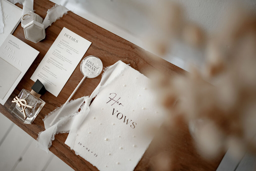 Hochzeitspapeterie Set mit Prägung auf der Einladungskarte und Save the Date Karte. Perlen Details auf dem Briefumschlag und dem Ehegelübde. Findet euren Papeterie-Stil passend zu eurem Hochzeitstil