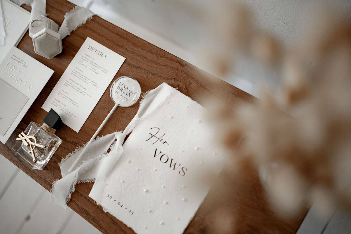 Hochzeitspapeterie Set mit Prägung auf der Einladungskarte und Save the Date Karte. Perlen Details auf dem Briefumschlag und dem Ehegelübde. Findet euren Papeterie-Stil passend zu eurem Hochzeitstil